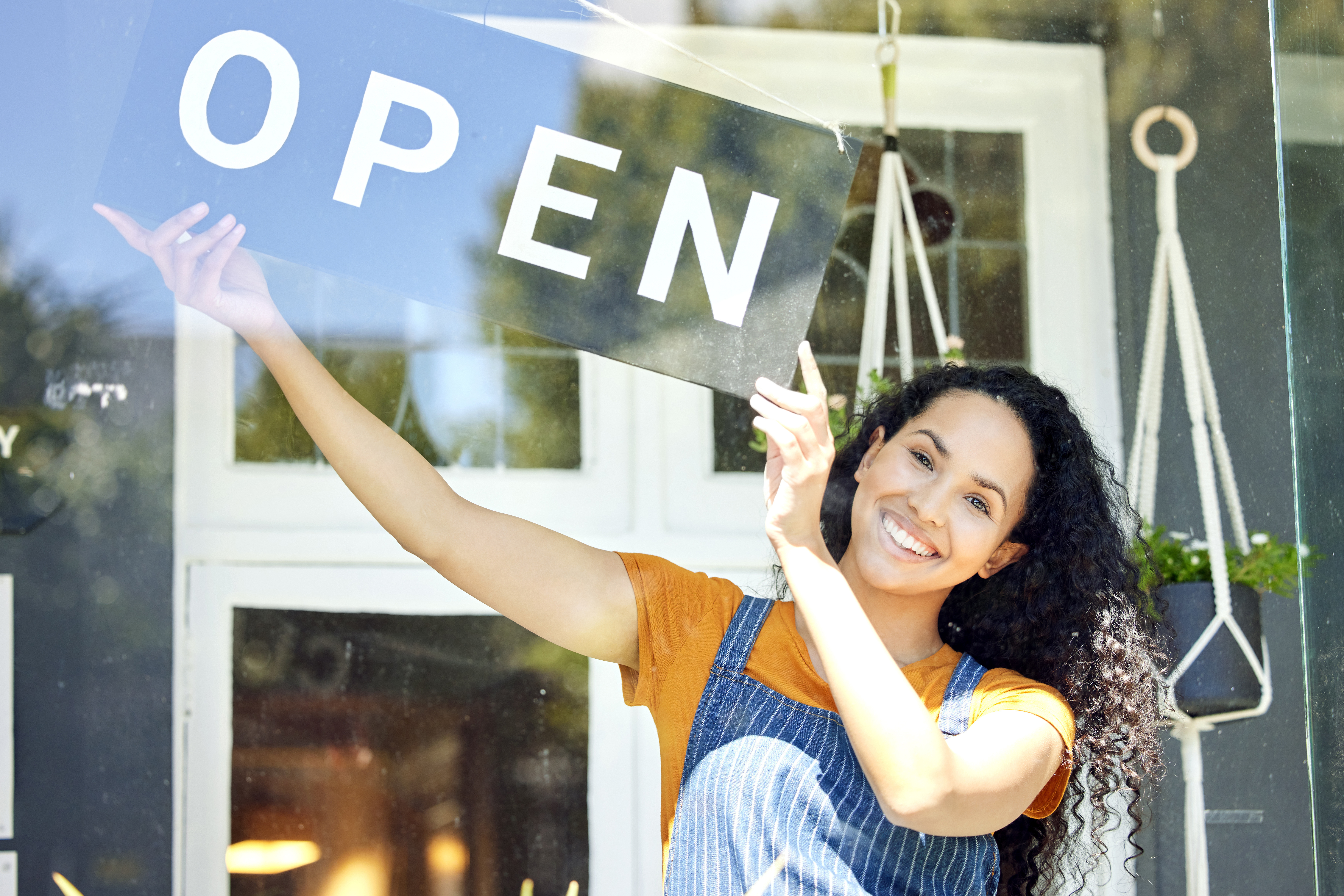 A small business owner turning the sign to open